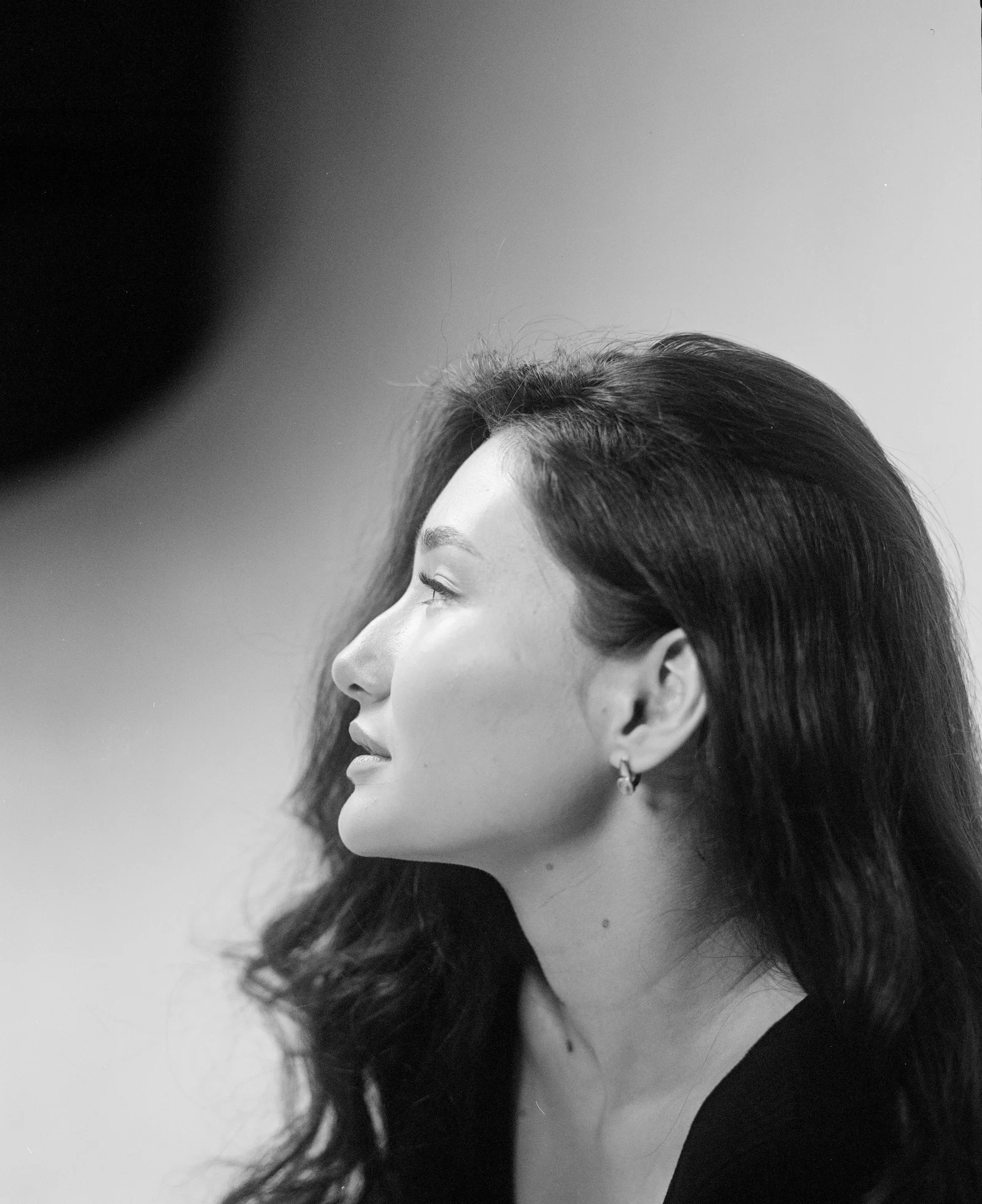 A woman with long hair sitting in front of a microphone
