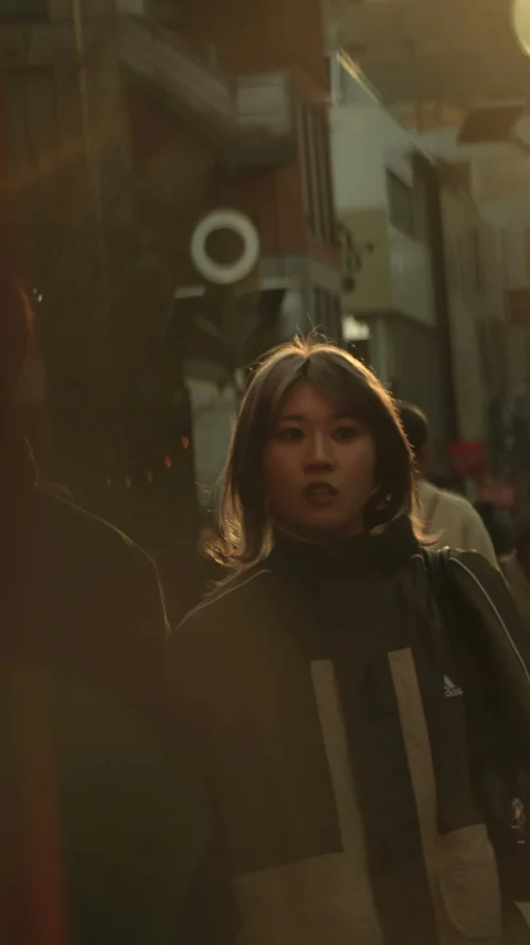 Young woman walking on a street at sunset