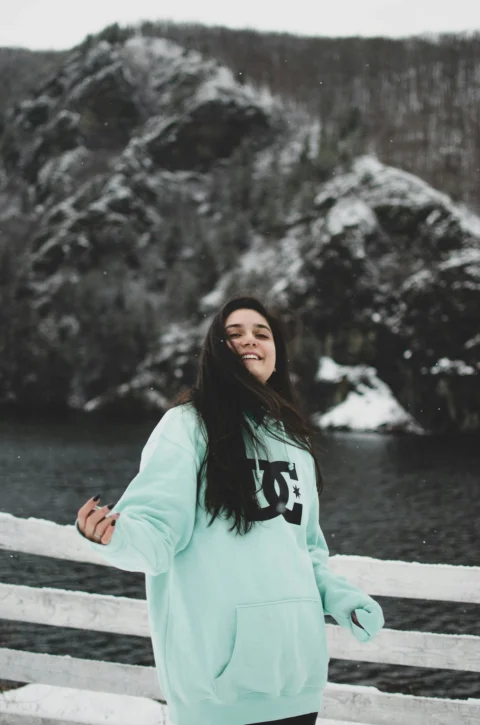 woman in white long sleeve shirt standing on snow covered ground during daytime