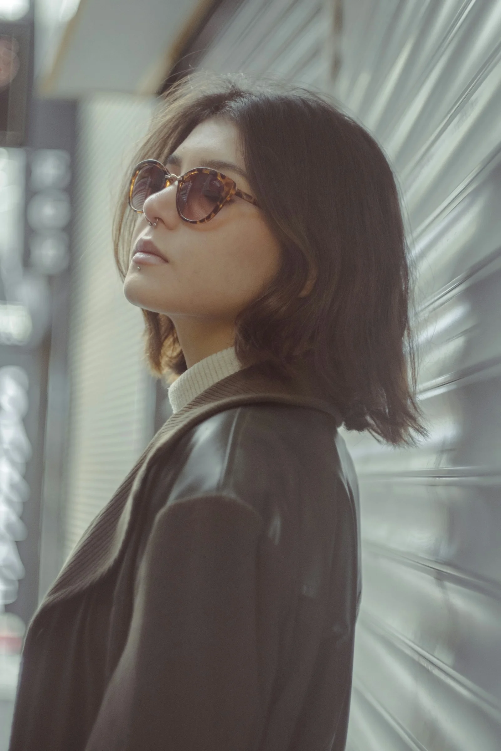 一名戴太陽眼鏡的女人站在牆前