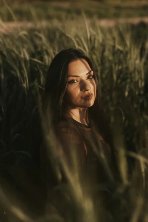 a woman standing in a field of tall grass