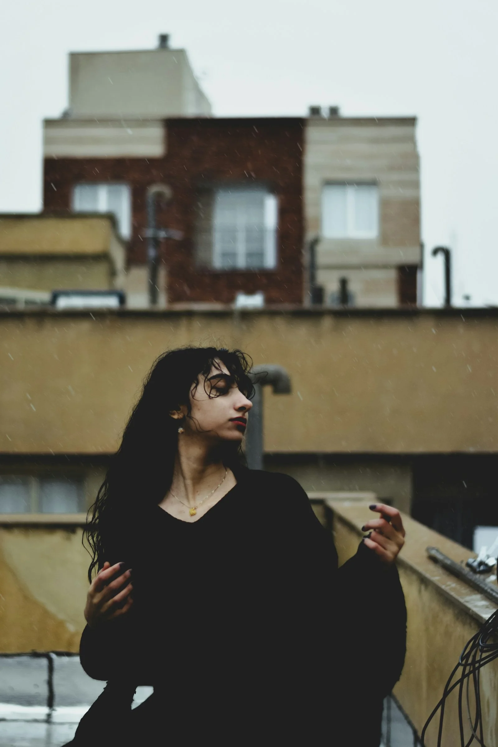 A woman standing on top of a roof next to a building