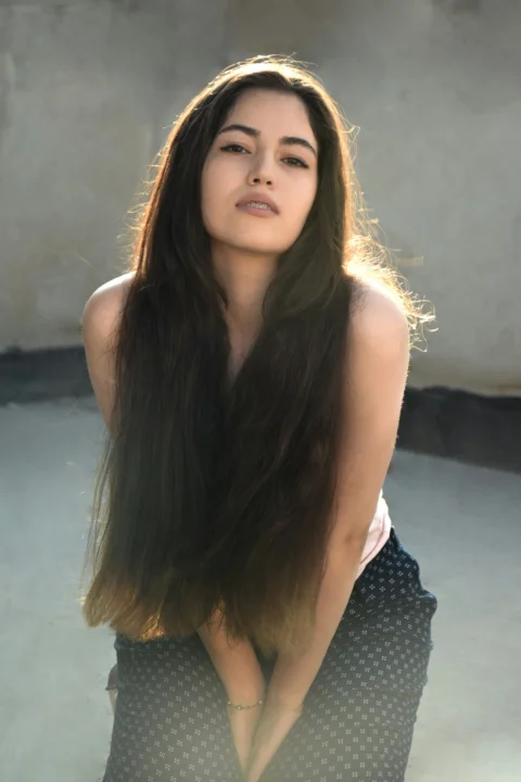 A woman with long hair is posing for a picture