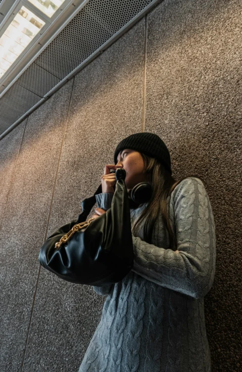 一个女人一边打电话一边拿着手提包