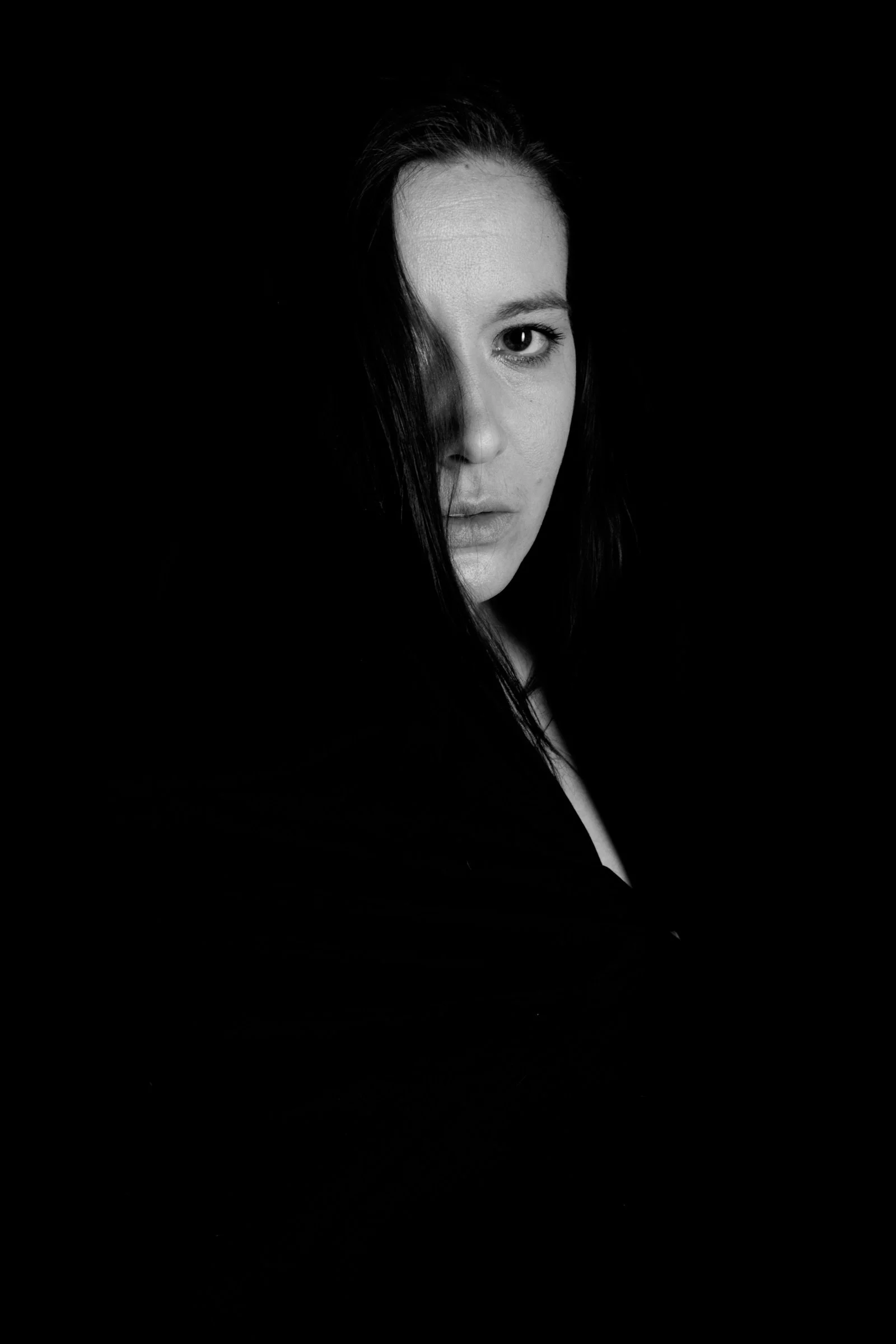a woman with long hair standing in the dark