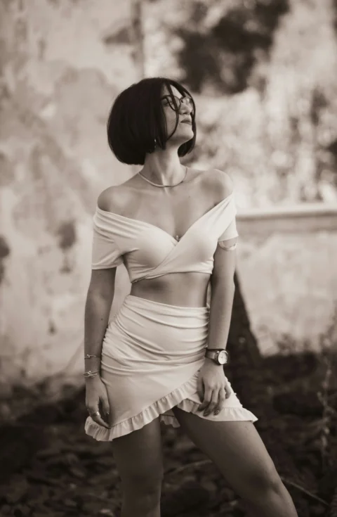 a woman in a white dress posing for a picture