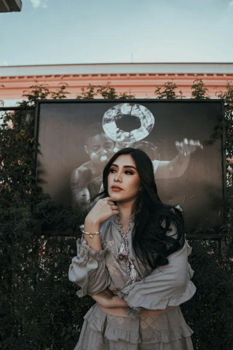 Woman poses in front of a black and white photo