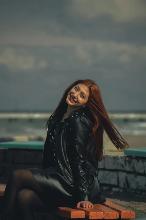 a woman with red hair sitting on a bench