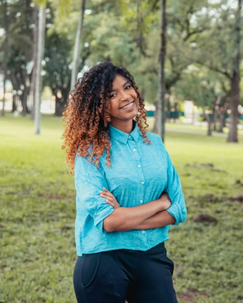 woman in blue long sleeve shirt standing on green grass field during daytime