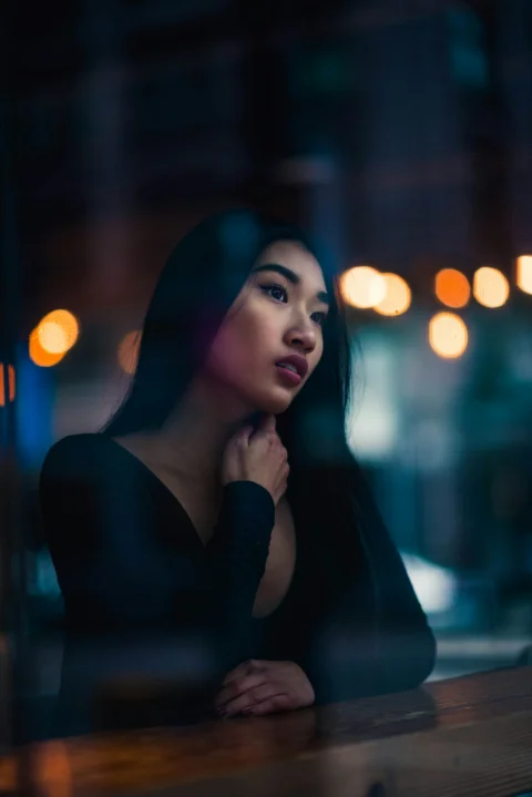 a woman sitting at a table with her hand on her chin