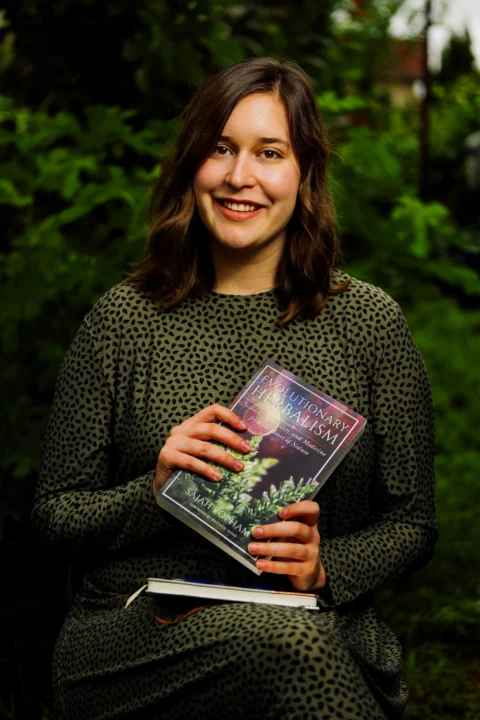 A woman sitting on a bench holding a book