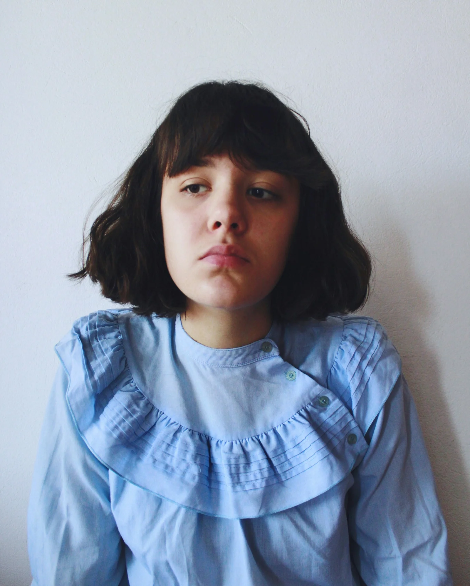 a young girl in a blue shirt poses for a picture