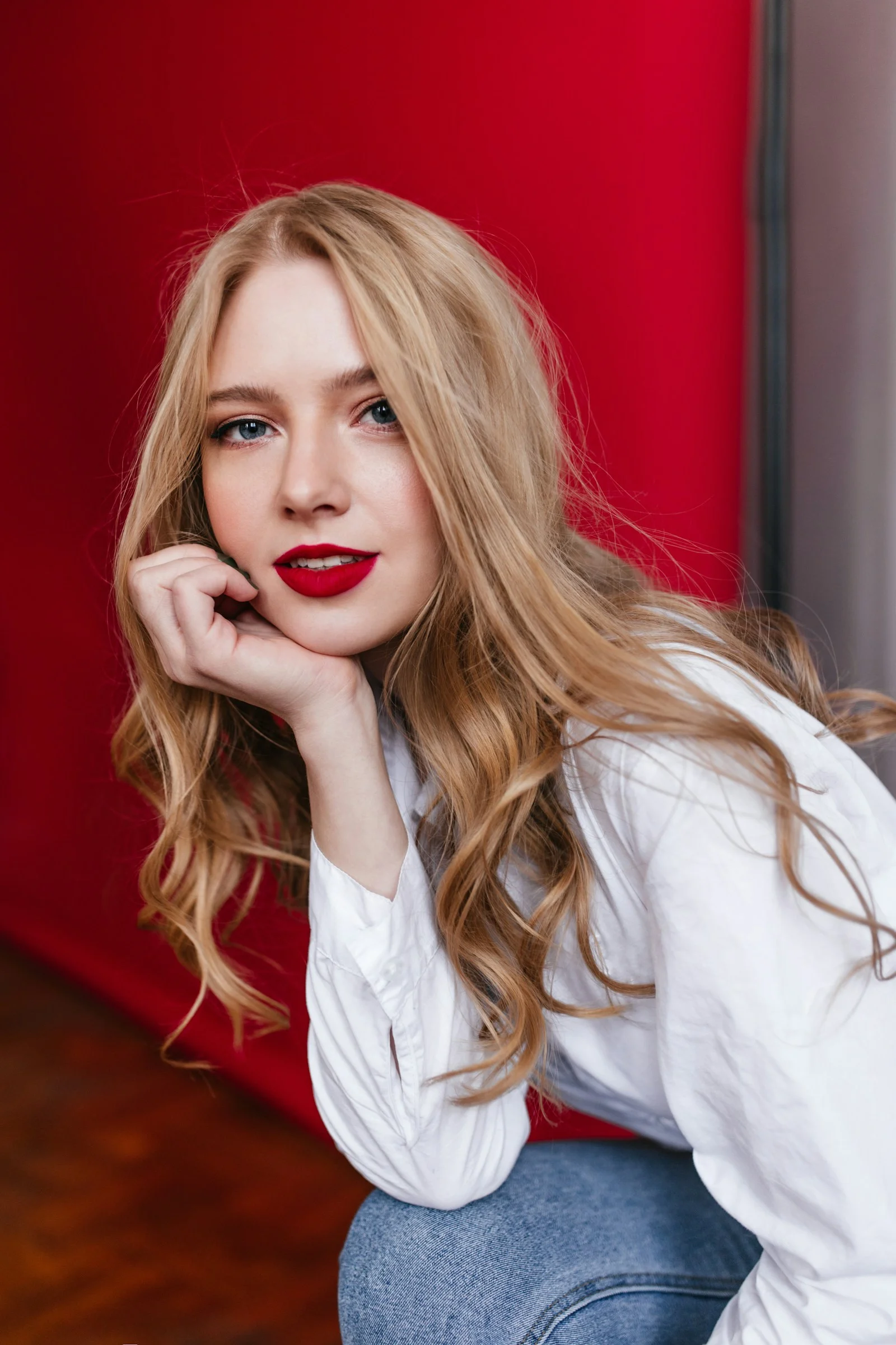 a woman with long blonde hair and red lipstick