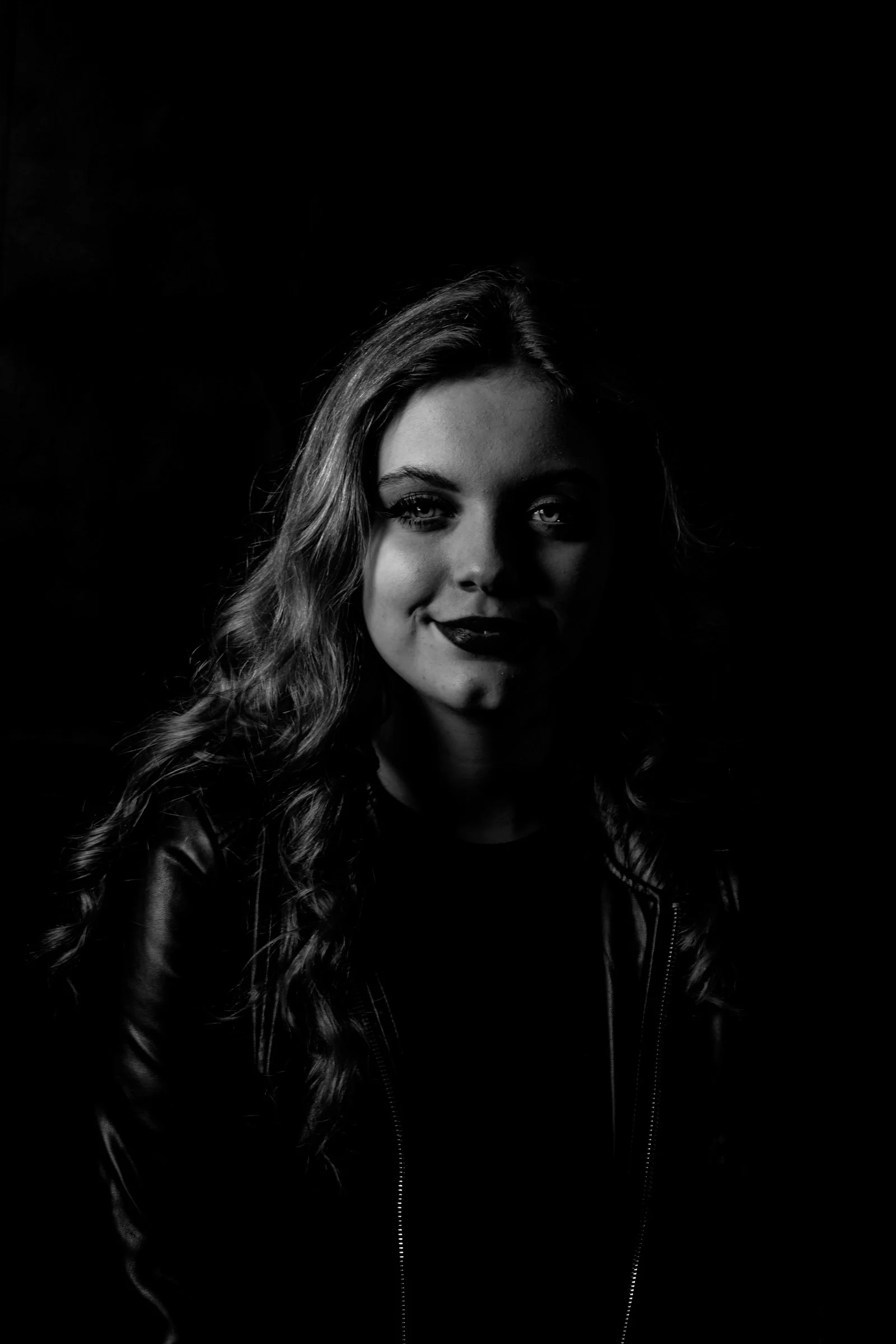 a black and white photo of a woman smiling