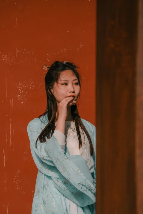 一位站在红墙前的女士