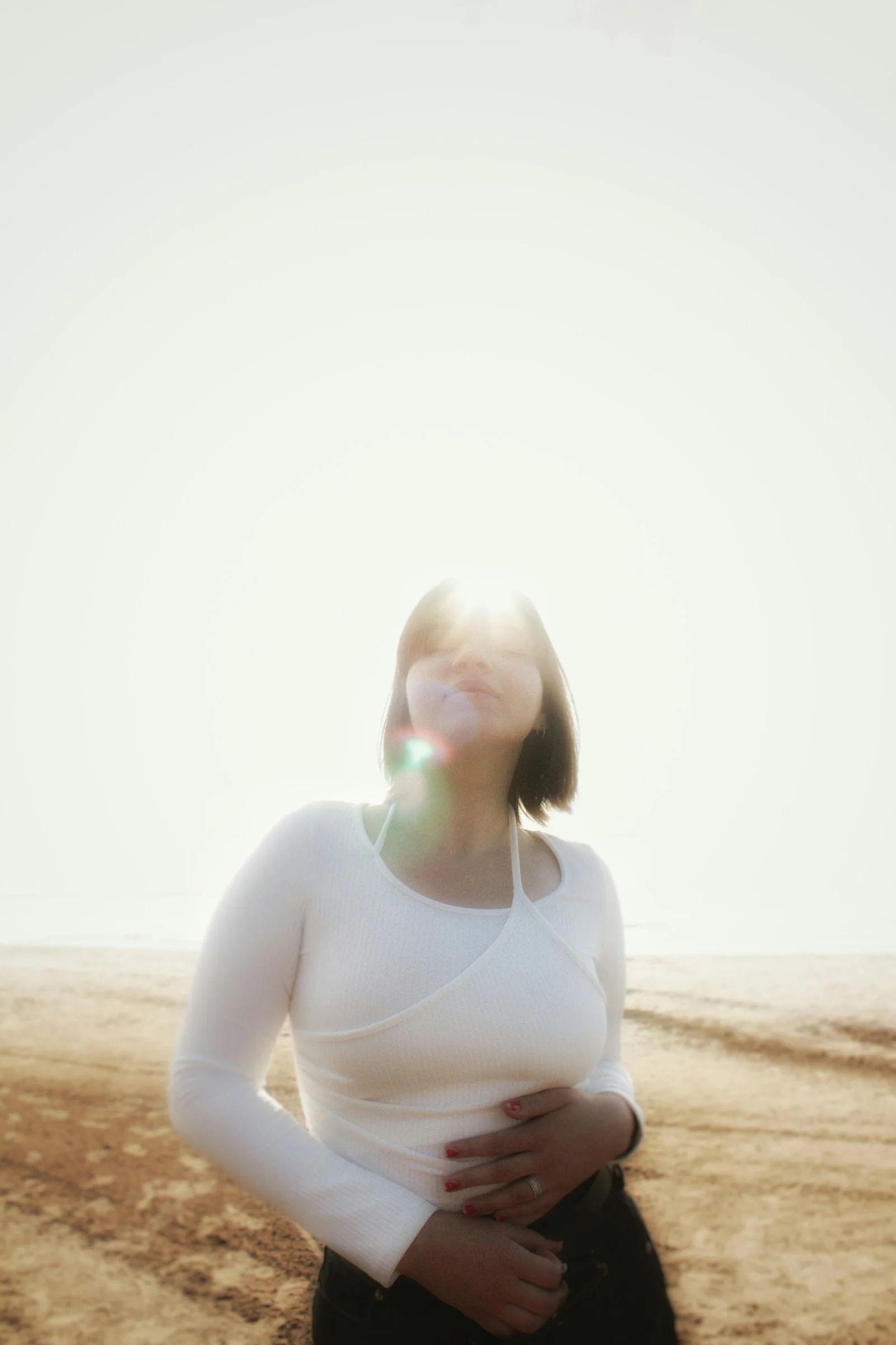 a woman in a white top is standing in the desert