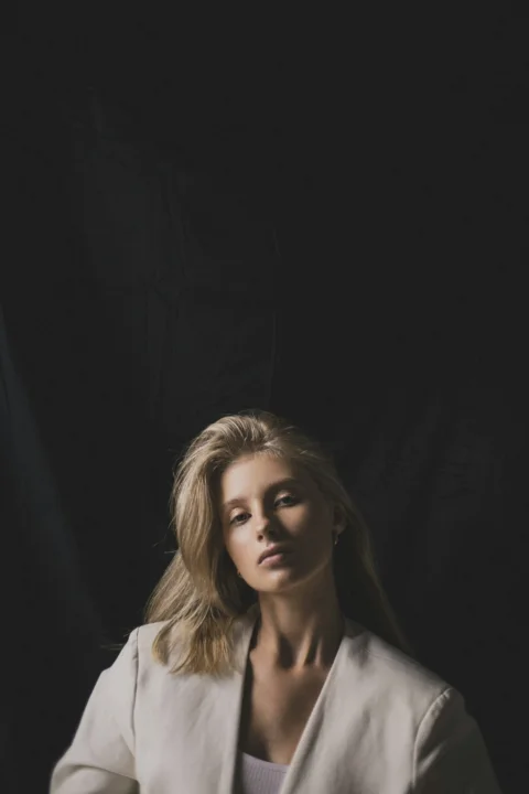 Blonde woman in a blazer looking at the camera