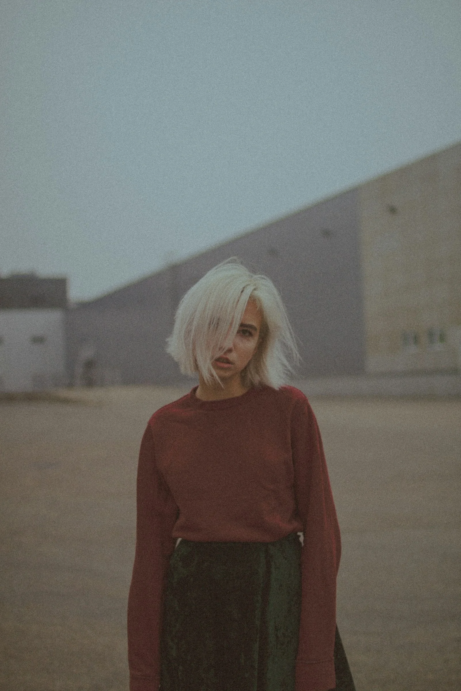 woman in red long sleeve shirt standing on brown field during daytime
