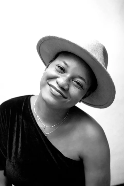 A black and white photo of a woman wearing a hat