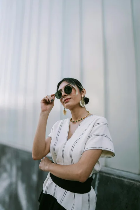 Woman poses confidently while wearing sunglasses