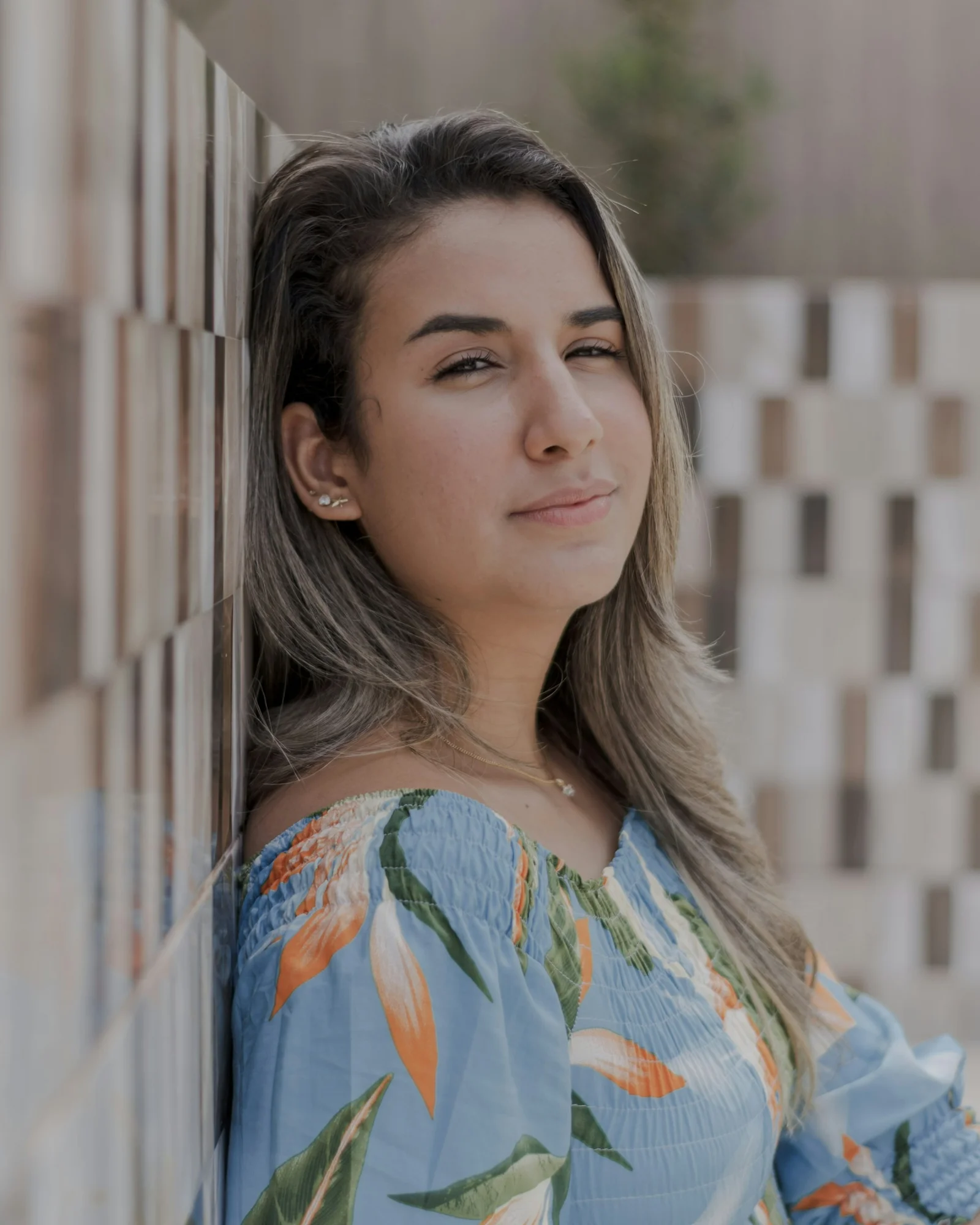 a woman leaning against a wall with her eyes closed
