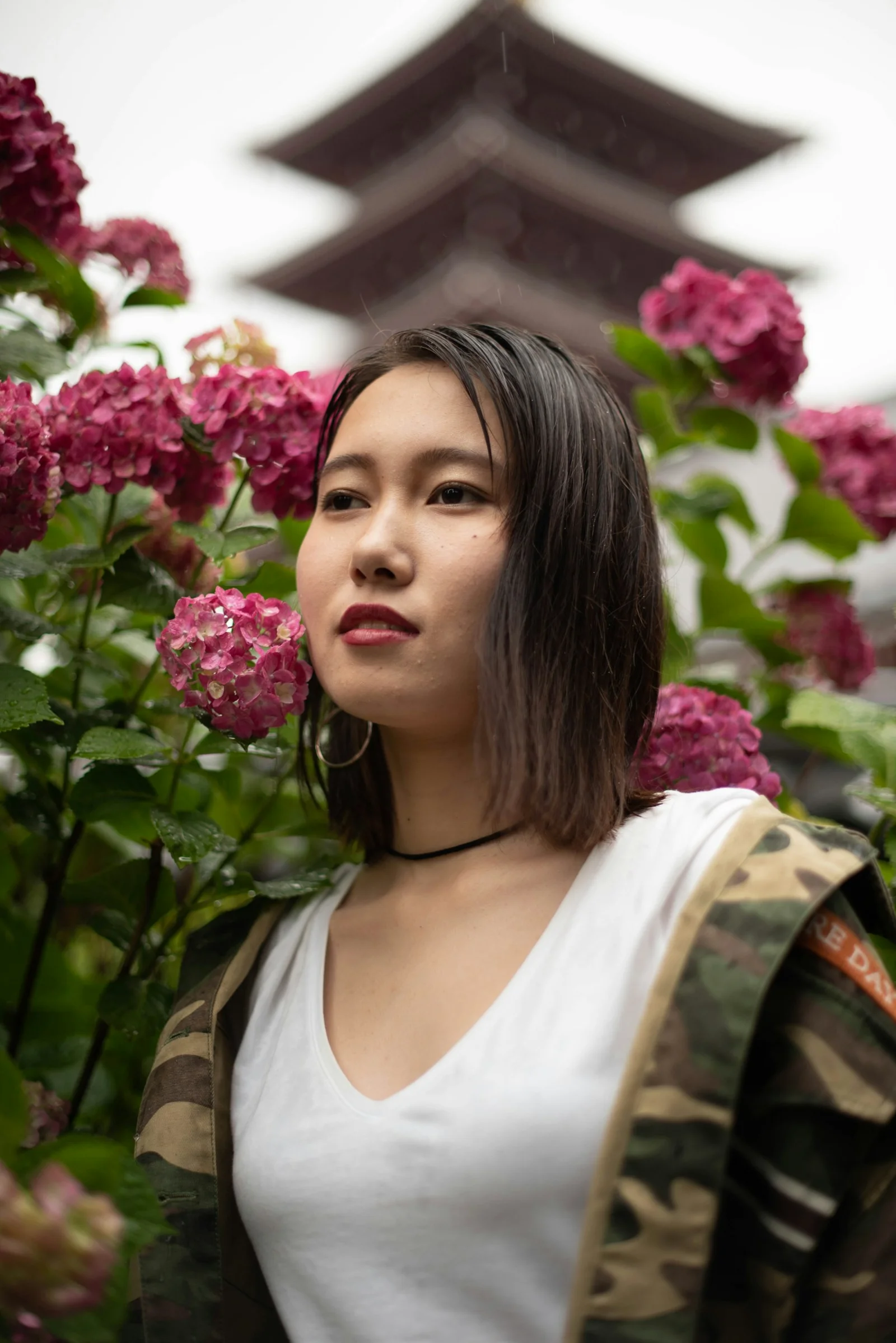 분홍색 꽃 앞에 서 있는 여성