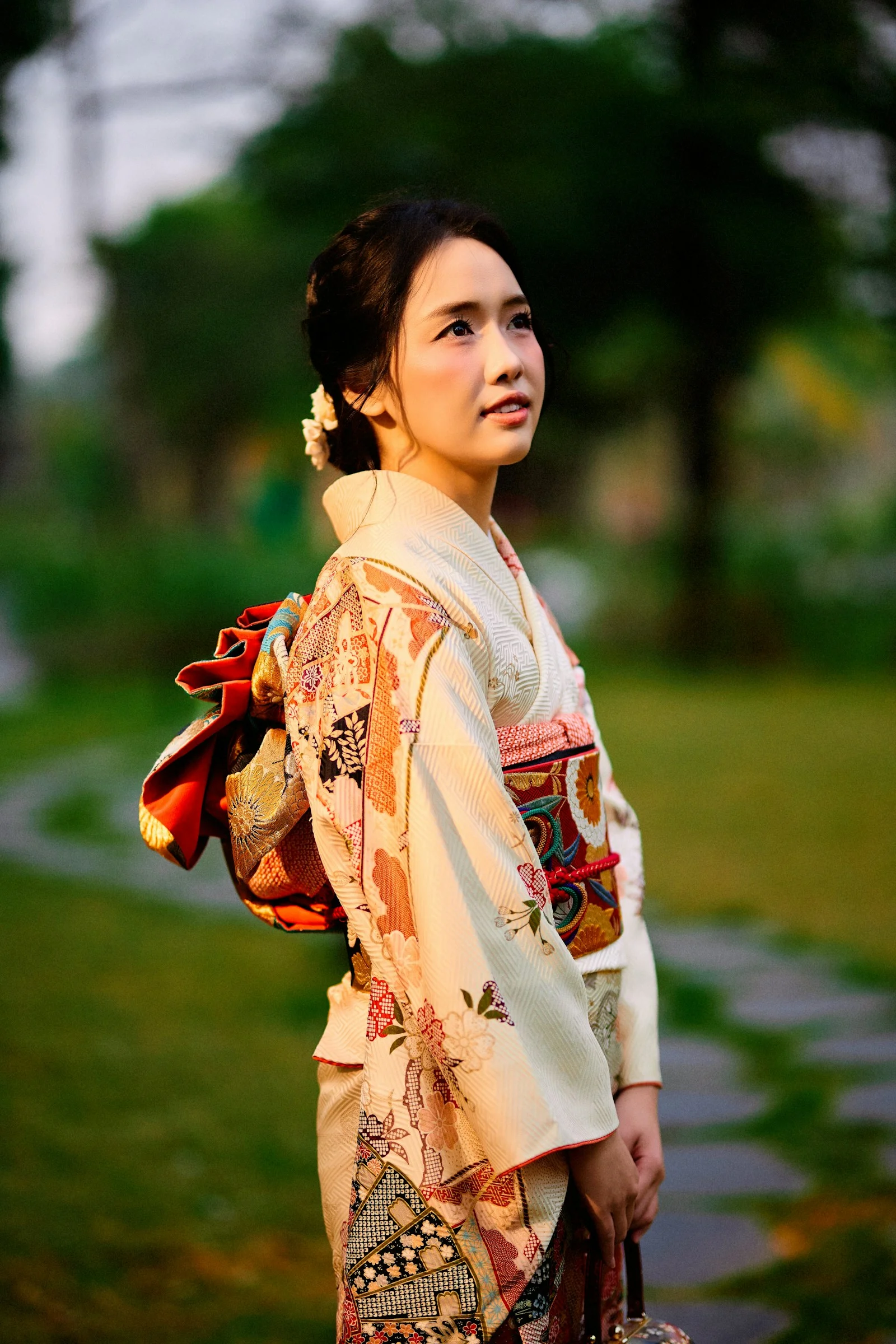 Woman in traditional japanese kimono looking up in a garden