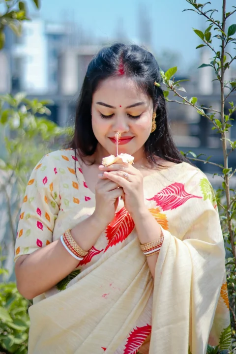 A woman is holding a flower and smiling