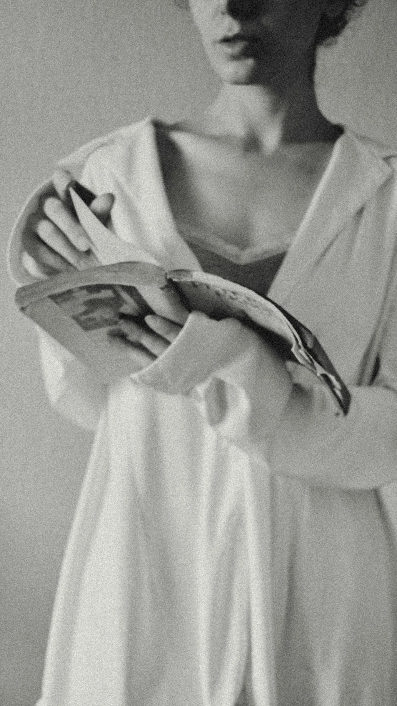 Woman in white shirt reading an open book