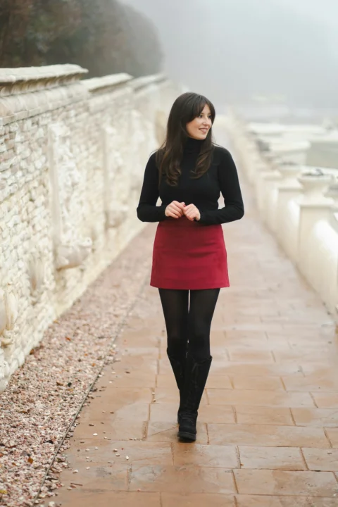 A woman in a red skirt is walking down a path