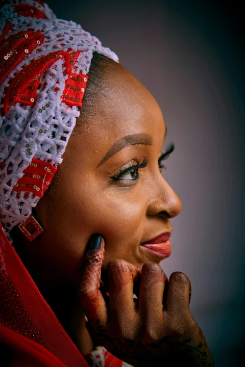 A woman with a headscarf looks thoughtfully