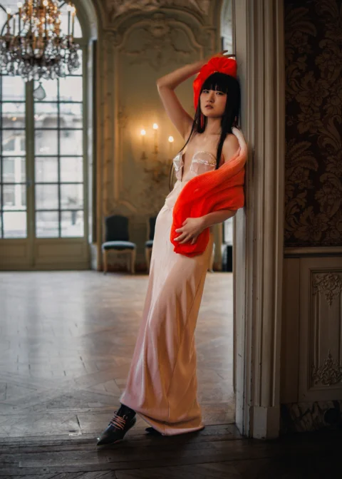 A woman in a long dress and a red hat