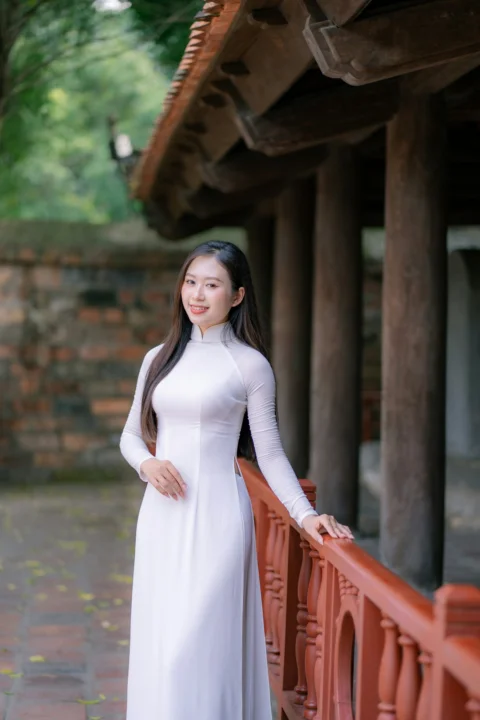 美丽的女子身穿传统白色连衣裙摆姿势