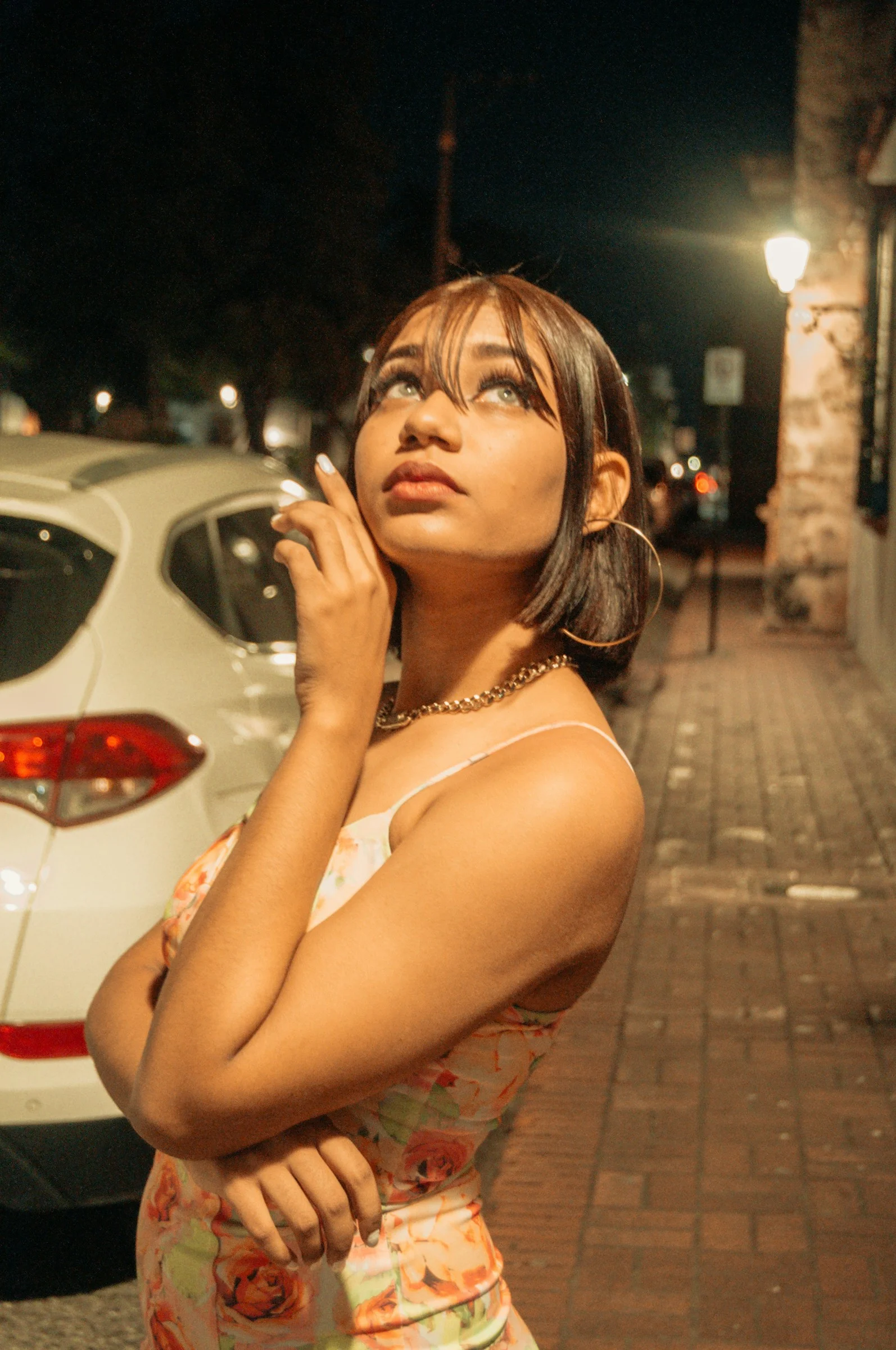 a woman standing next to a white car