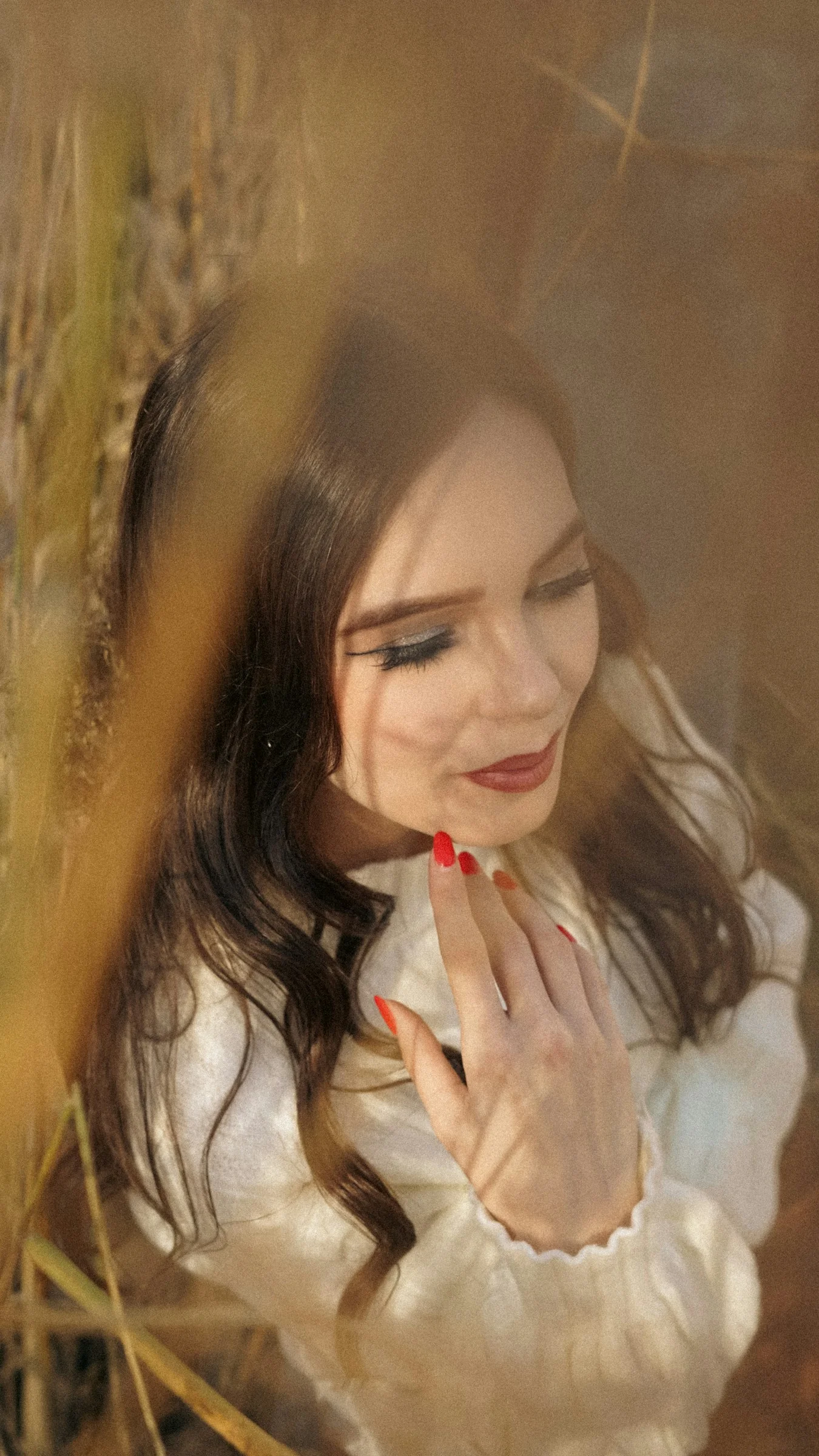 A woman with dark hair wearing a white shirt outdoors