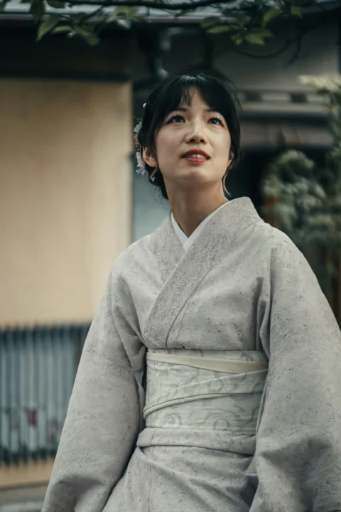 a woman in a kimono standing in front of a building