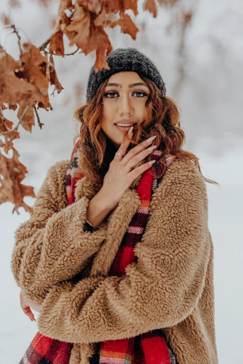 一个双手捂住嘴巴站在雪中的女人