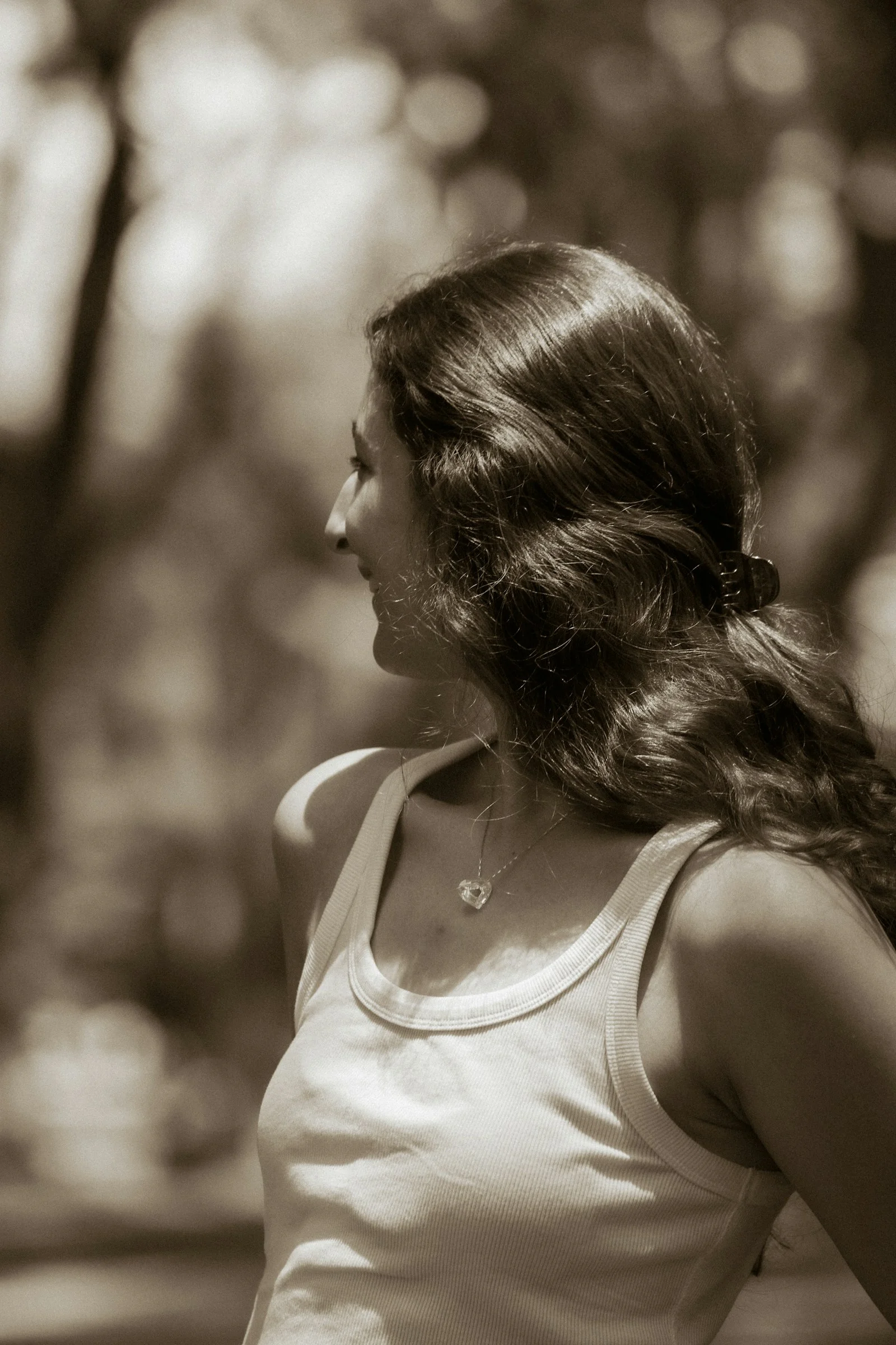 A woman with long hair looking right in sepia tone