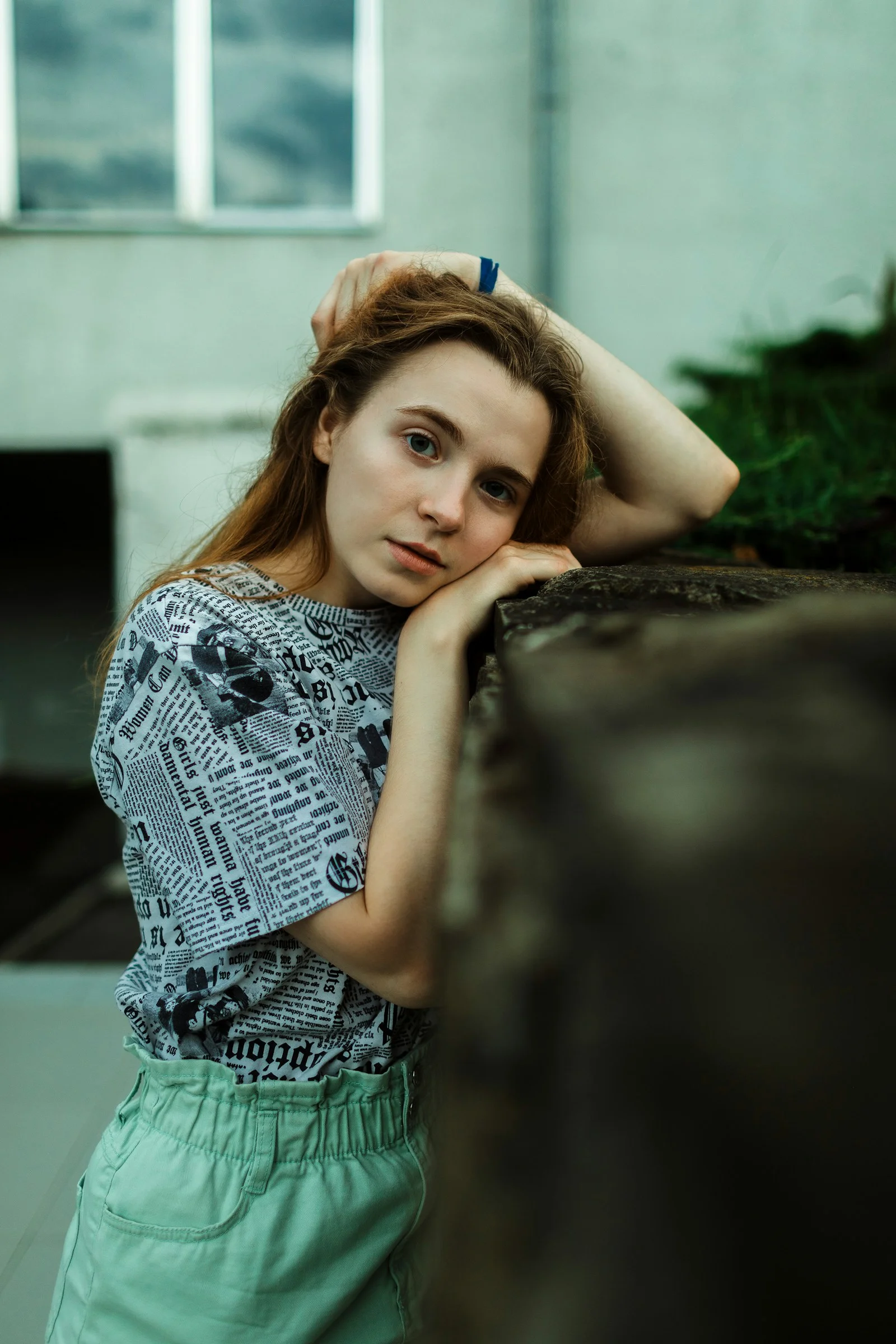 Young woman resting her head on a wall