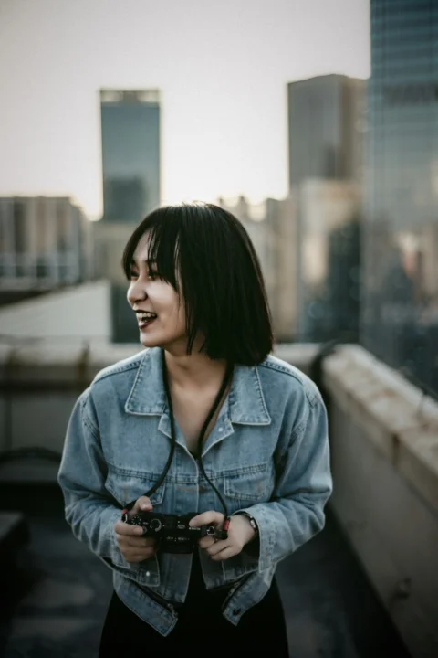 a woman standing on a roof holding a camera