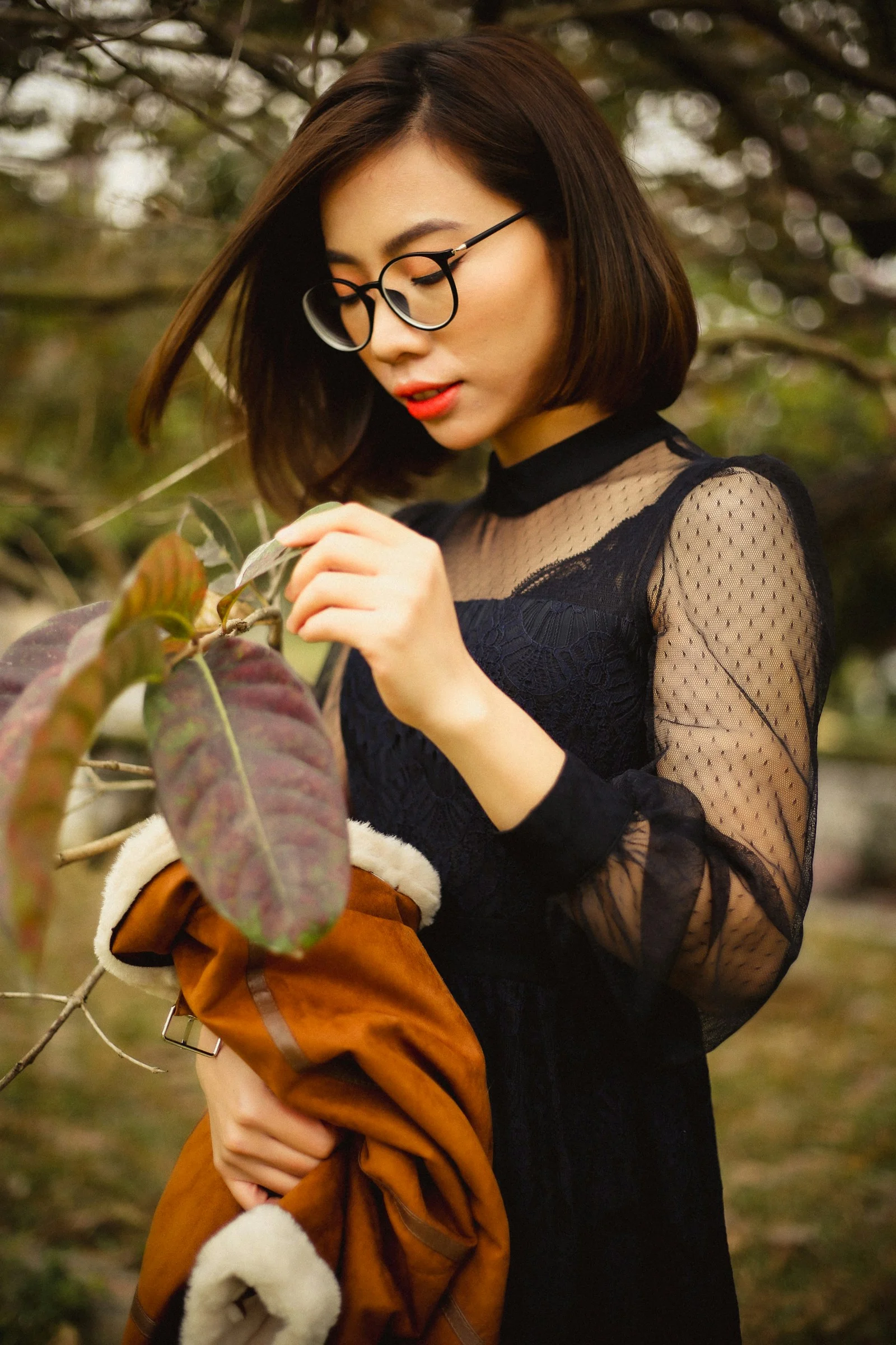 一位戴眼镜、手持树叶的女子