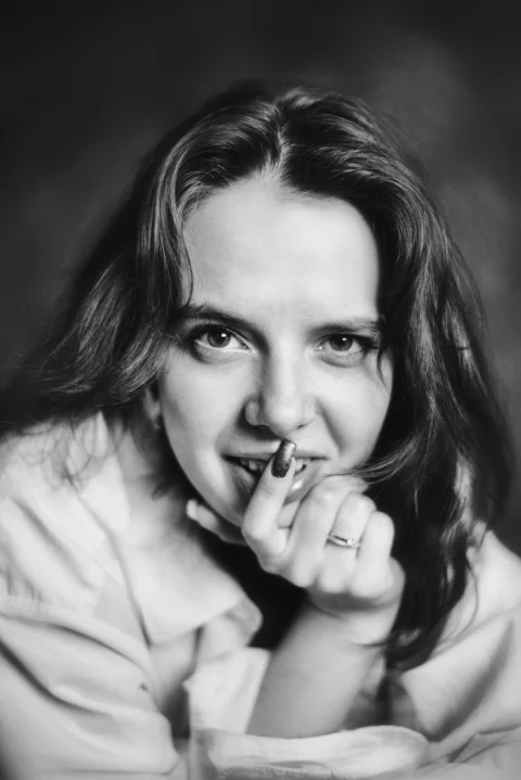 A black and white portrait of a woman smiling