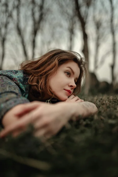 a woman laying on the ground in the grass