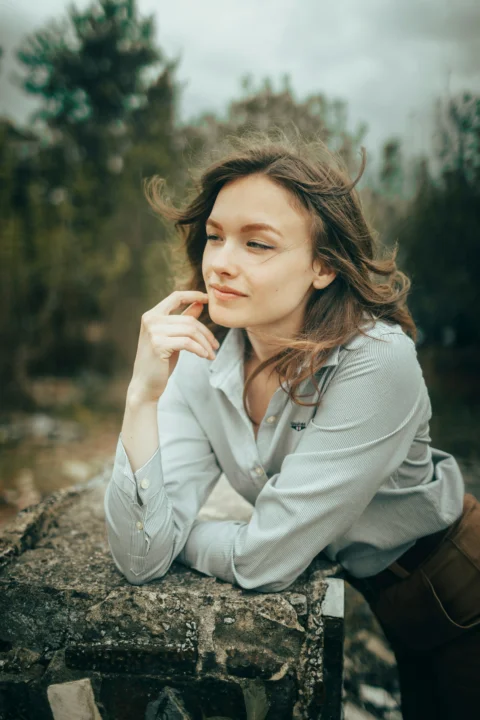 Young woman with windswept hair looking away