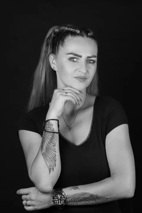 A black and white photo of a woman with tattoos