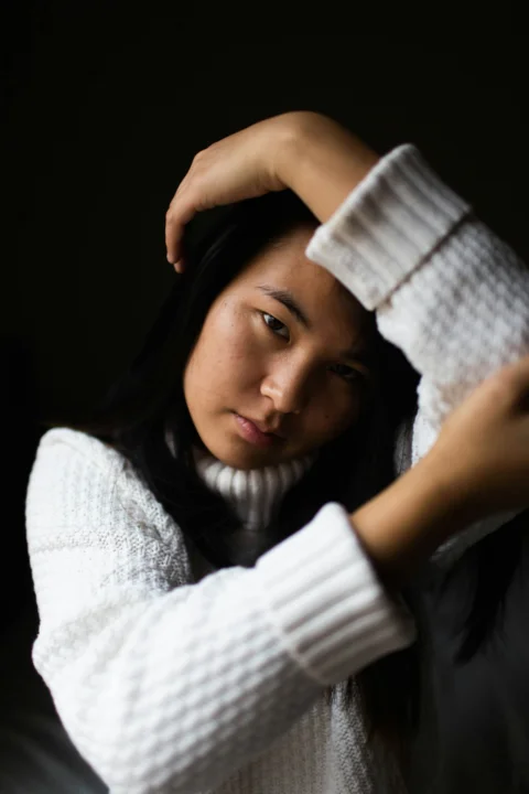 左臂搭在头上的女子