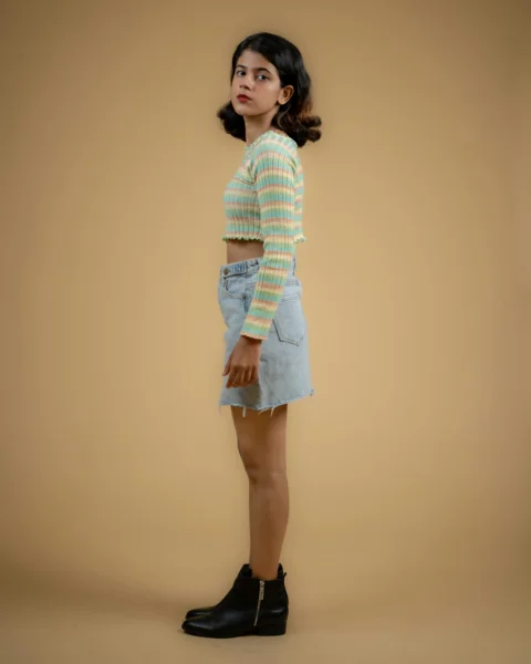 a young girl in a striped shirt and denim skirt