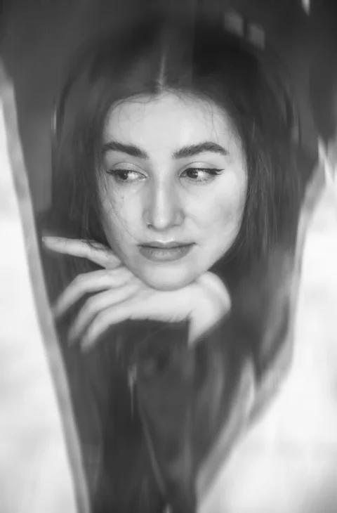 A pensive woman poses in black and white