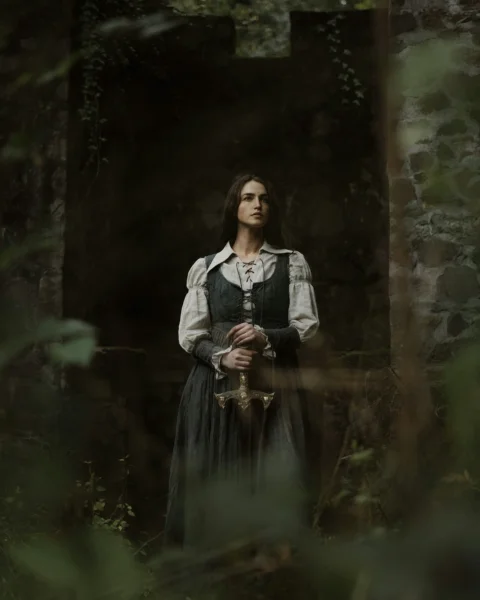 a woman in a dress standing in a forest