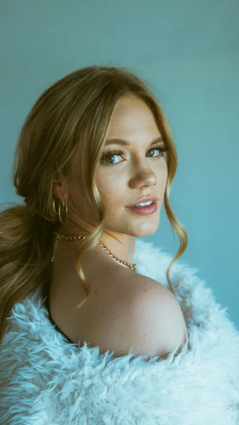woman in white fur top wearing silver necklace